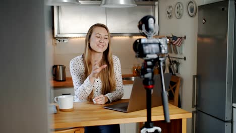 Feliz-joven-hermosa-rubia-mujer-blogger-de-moda-filmando-nuevo-video-vlog-para-las-redes-sociales-en-casa-cámara-lenta.