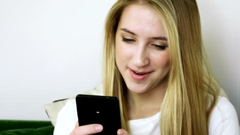 Young-smiling-woman-using-smartphone,-texting-on-mobile-phone-in-modern-cafe.-4K