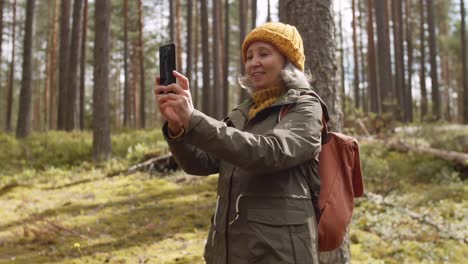 Old-Woman-Making-Photos-of-Nature-in-Forest