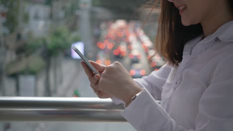 Close-up-Hand-of-Business-woman-celebrating-good-news-checking-smart-phone-in-the-modern-city-center-in-the-evening-of-Bangkok-Thailand.-Concept-Technology-communication-by-mobile-phone