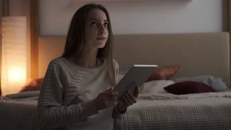 Teen-Mädchen-mit-digitalen-Tablet-im-Schlafzimmer-in-der-Nacht