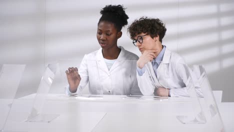 Two-Female-Scientists-Discussing-Computer-Models-on-AR-Touchscreens