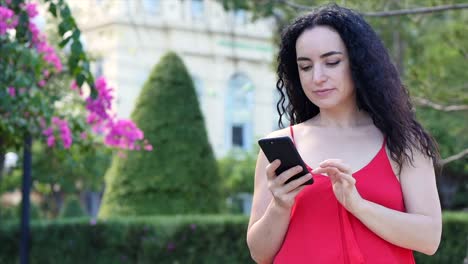 European-Young-Girl-or-Woman-Cute-Cheerful-Girl-Brunette-typing-texting-on-the-smartphone,-woman-talking-on-phone.-Young-woman-calling-via-mobile-phone.-Young-woman-checking-mail-by-mobile-phone.