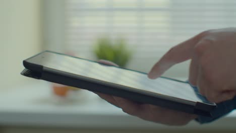 Man-using-tablet-computer-online-shopping-working-from-home.-Close-up.