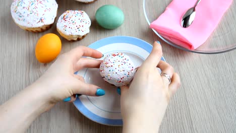 Hands-put-on-the-table-a-plate-with-a-Easter-cake-with-white-icing.