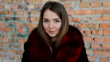 Portrait-of-a-cute-girl-on-the-brick-wall-background.Full-hd-video