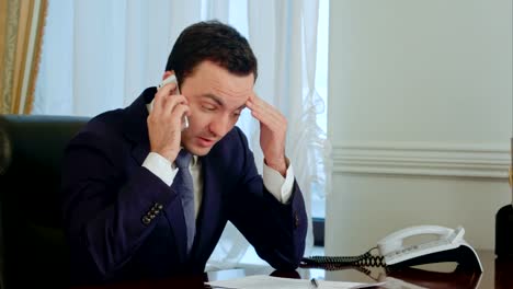 Young-serious-businessman-take-a-phone-call,-having-a-conversation-and-getting-pensive