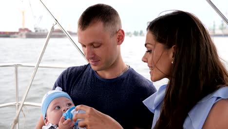 Kind-seine-ersten-Früchte-essen,-in-Händen-Papa,-Familie-mit-Baby-auf-Urlaub,-Eltern-und-Kinder-am-Meer,-glückliche-Paar-auf-yacht