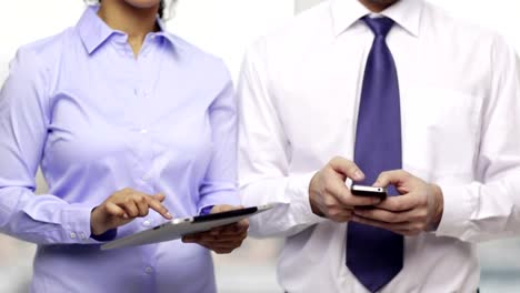 empresario-y-empresaria-con-smartphones-en-oficina