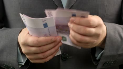 Man-in-grey-suit-counting-euros,-close-up-of-businessman's-hands-holding-cash