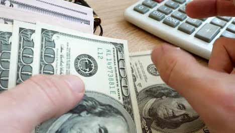 Close-up-of-counting-money.-Dollar-banknotes-on-a-table.