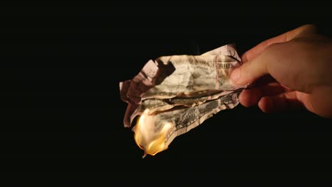 Burning-dollars-close-up-over-black-background