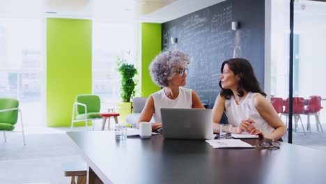 Mujer-jefe-hablando-con-compañero-de-trabajo-en-una-reunión-informal