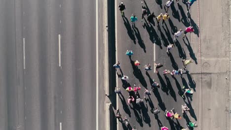 Fooage-aérea-drone-de-4K.-Maratón-de-correr-en-la-calle.-Tras-la-cámara.-Vista-superior-cerrar