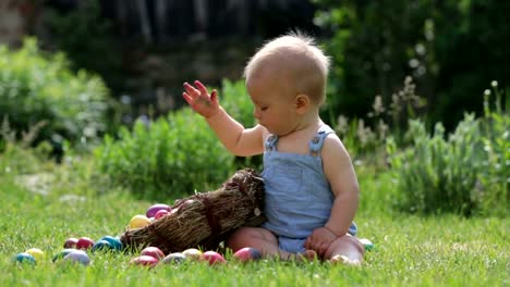 Niedlichen-Kind,-spielt-mit-kleinen-Häschen-und-Ostern-Eier-in-einen-blühenden-Garten,-Frühling.-Junge-mit-Kaninchen-spielen,-Ei-Jagd-für-Urlaub