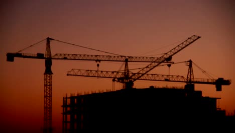 Construction-of-high-rise-building-against-on-the-background-of-sunrise,-time-lapse