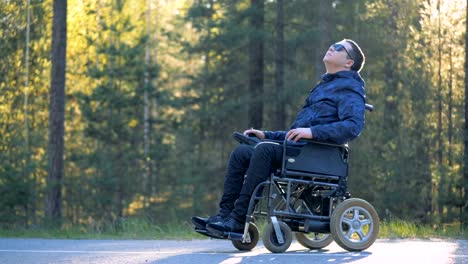 Handicapped-person-in-a-wheelchair-is-enjoying-himself-and-surrounding-nature