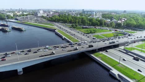 Mehrstufige-Straßenkreuzung-am-blauen-Fluss-mit-Brücke-und-Lastkähne