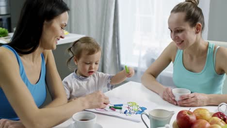 Niño-con-dos-madres-del-colorante-en-la-cocina