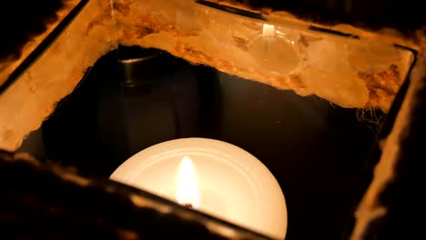 Candle-in-a-restaurant-on-a-black-background-in-a-candlestick.