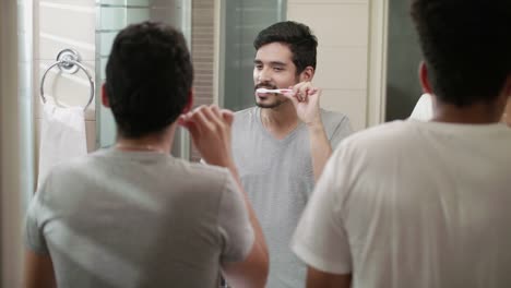 Pareja-Gay-feliz-sonriendo-y-cepillar-los-dientes-en-el-baño