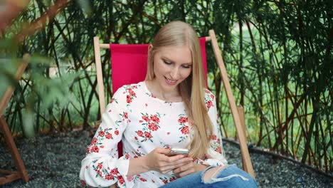 Young-woman-using-smartphone-in-plant-gazebo