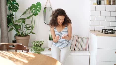 Young-woman-typing-on-mobile-phone-at-home.