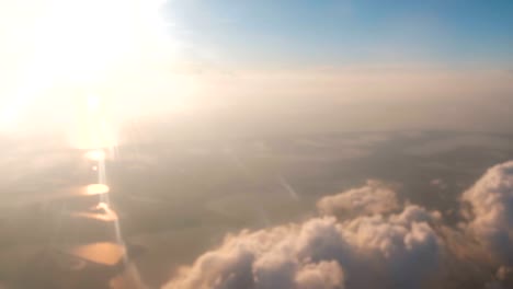 Hermosa-vista-desde-la-ventana-de-la-aeronave-en-tierra,-mar,-sol-y-nubes.