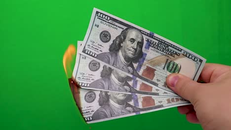 100-dollars-burning-on-a-green-background.-Concept-of-downturn-in-economy-and-loss