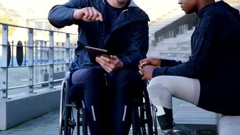 Two-disabled-athletics-discussing-over-digital-tablet-4k