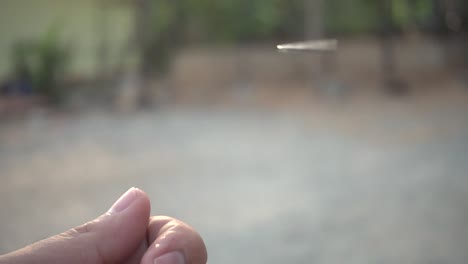 Man-tossing-a-coin-on-white-background-in-slow-motion