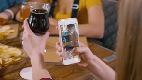 Girl-taking-a-photo-of-glass-with-ale