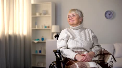 Granddaughter-hugging-smiling-old-woman-in-wheelchair,-family-love-and-care