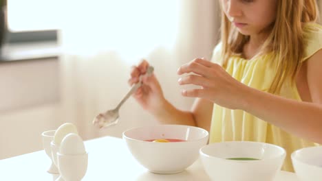 girl-coloring-easter-eggs-by-liquid-dye-at-home