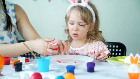 Madre-ayudando-a-la-hija-a-pelar-un-huevo-de-Pascua