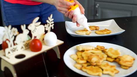 Mujer-poniendo-crema-en-galletas-de-Pascua