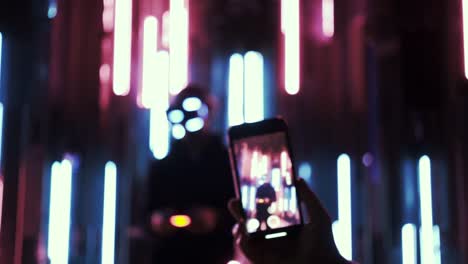 Detail-smartphone-screen-taking-photo-in-neon-light