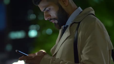 Young-Middle-Eastern-businessman-answering-messages-on-smartphone