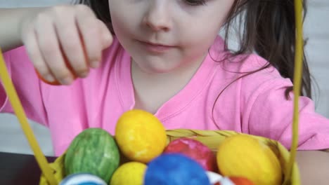 A-child-puts-Easter-eggs-in-a-basket.