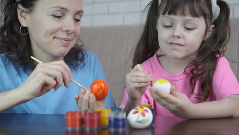 Una-mujer-con-un-niño-pinta-huevos-para-Pascua.