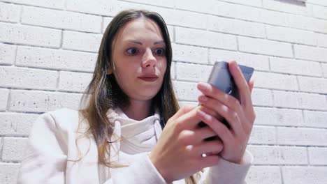 La-mujer-está-escribiendo-un-mensaje-en-el-teléfono-móvil-sentado-y-esperando-a-alguien-en-el-café.