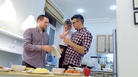 Familia-gay-con-hija-niño-cocinar-pizza-juntos-en-la-cocina.