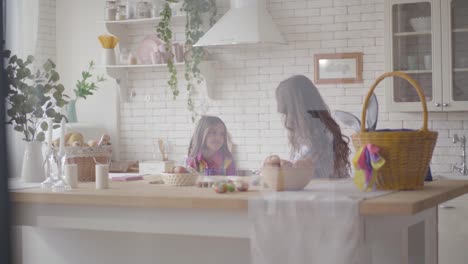 Young-mother-and-her-preteen-daughter-talking-on-the-kitchen.