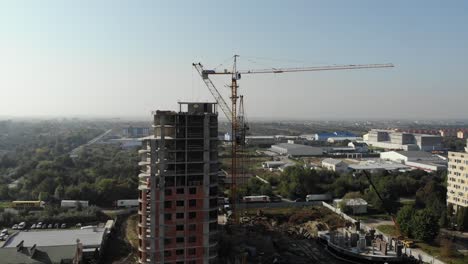 An-aerial-view-of-a-residential-building-in-construction.-Tower-cranes-working-by-the-building.-4K