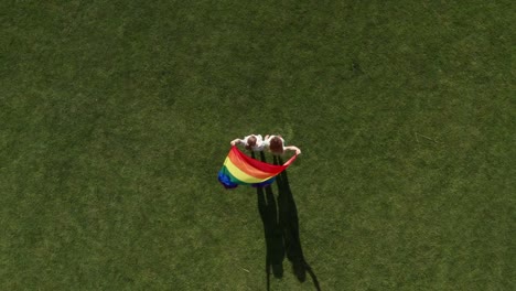 Drone-shot-of-gay-couple-with-fluttering-lgbt-flag