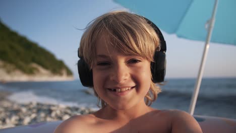 Cute-child-using-smart-phone-on-beach