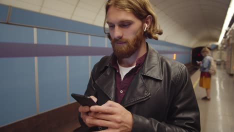 Ingwer-Mann-mit-Smartphone-an-U-Bahn-Station