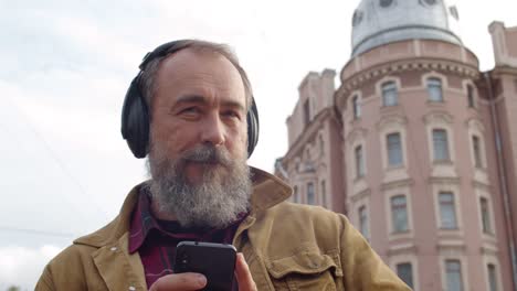 Senior-Enjoying-Music-during-Walk-in-Downtown