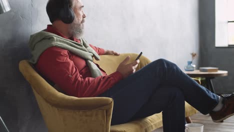 Man-Sitting-on-Sofa-and-Listening-to-Music