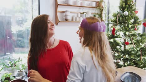 Gay-Female-Couple-At-Home-Dancing-In-Kitchen-As-They-Prepare-Dinner-On-Christmas-Day-Together